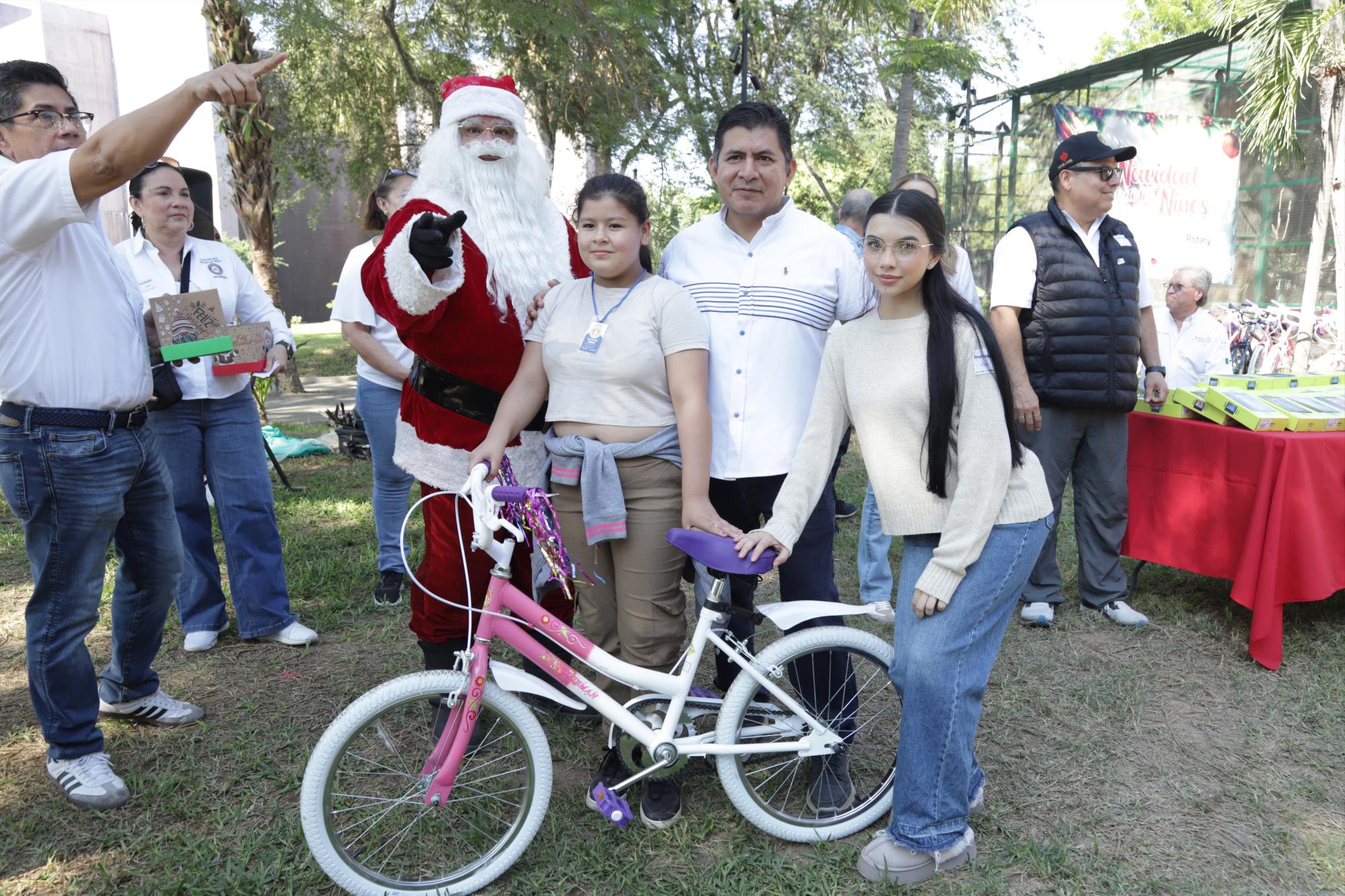 $!Brianda Valdez recibe una bicicleta por parte de Santa Clos, Marco Cruz y Alejandra Arreola.