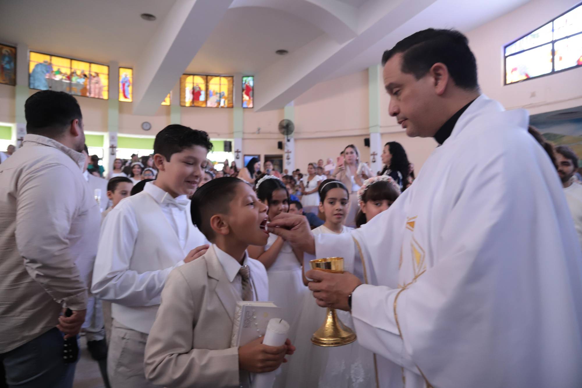 $!El pequeño al momento de recibir la hostia.