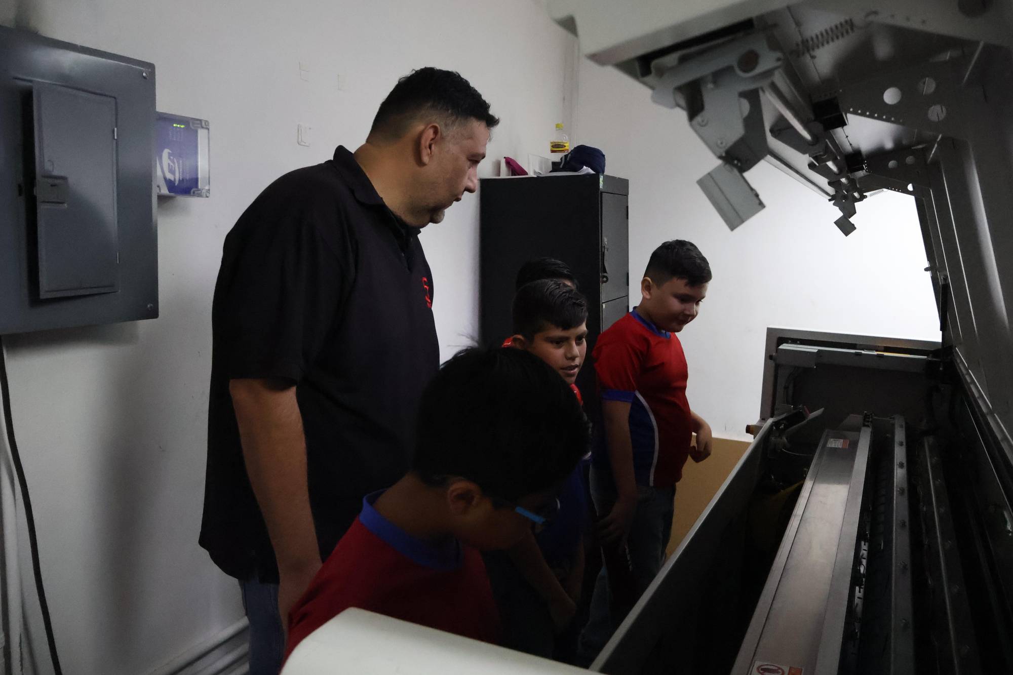 $!Gregory Sauceda, Administrador de proyectos, explica a los pequeños el funcionamiento de CTP, donde se generan las láminas para la prensa.