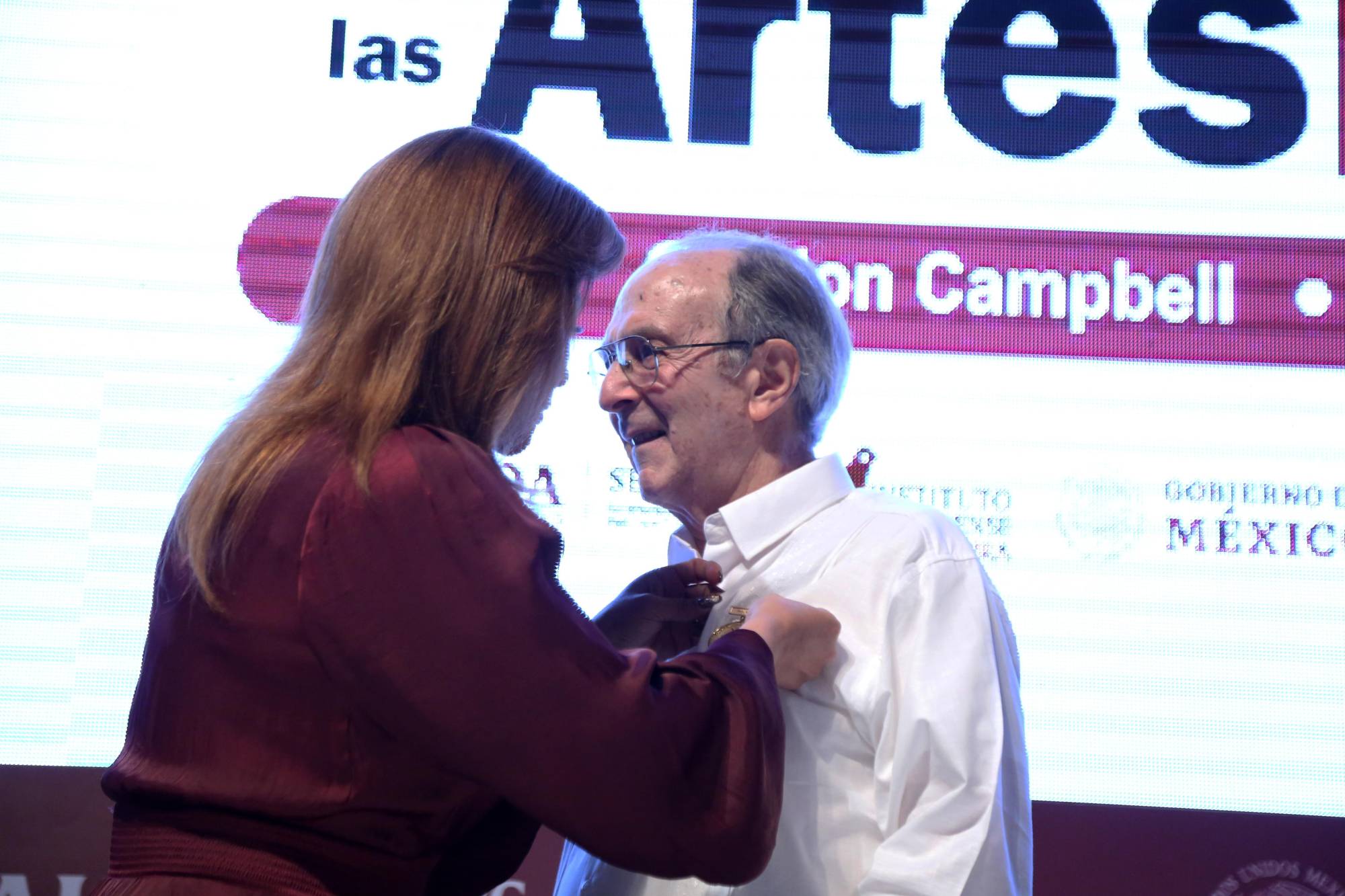 $!El director de orquesta también recibió una medalla que le colocó la secretaria Gloria Himelda Félix Niebla.