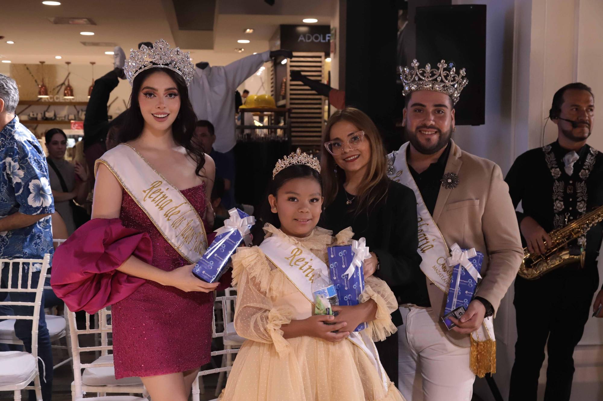 $!Magdalena Leyva, jefa de relaciones públicas de Cimaco Mazatlán, entre Desiré Ayón, Ángela Salazar y Brayan Gamboa, Reina de los Juegos Florales, Reina Infantil y Rey de la Alegría del Carnaval de Mazatlán 2025, respectivamente.