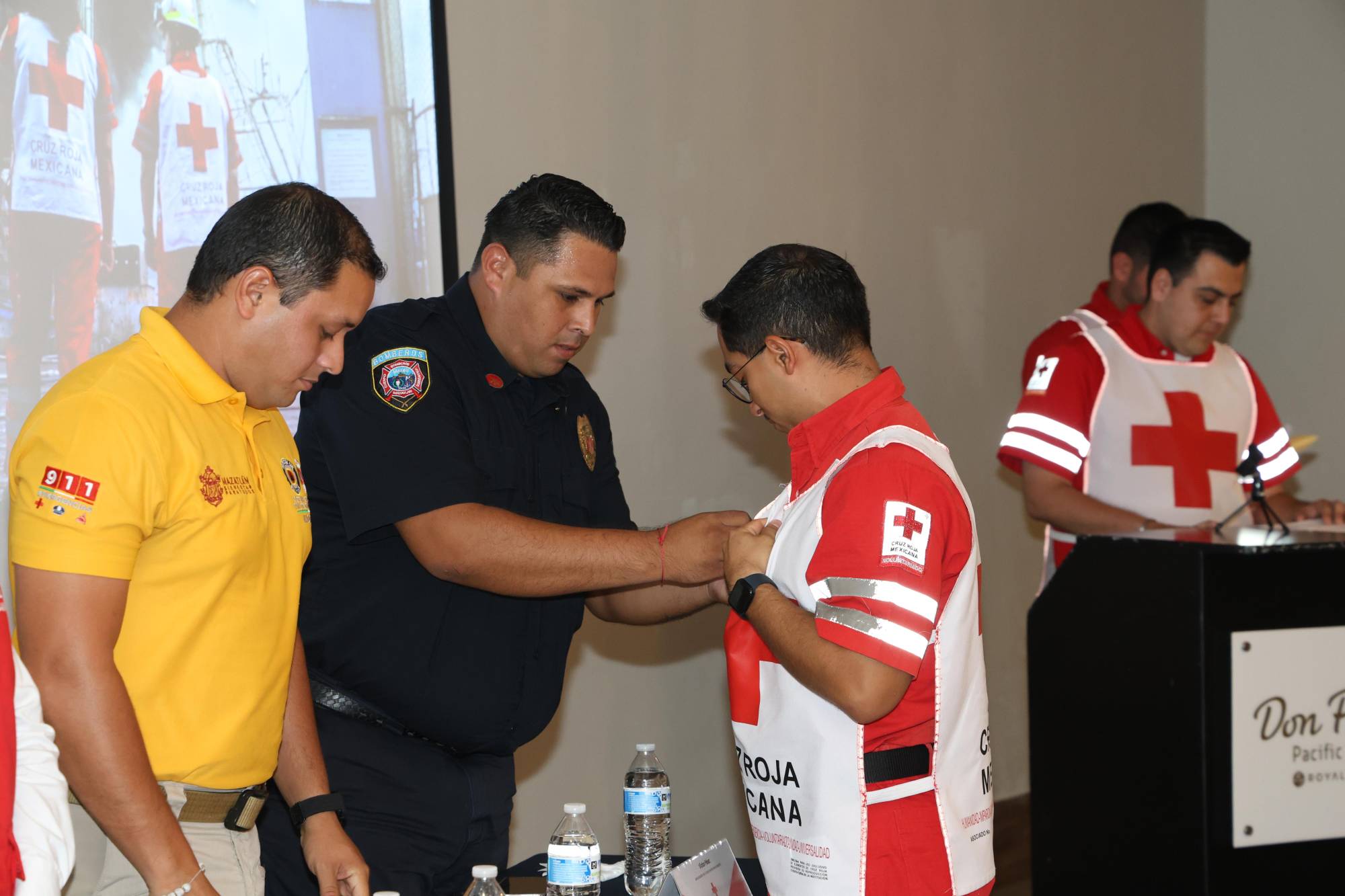 $!Víctor Páez, de Bomberos Mazatlán y quien fue invitado especial, hizo entrega de pin a algunos homenajeados.