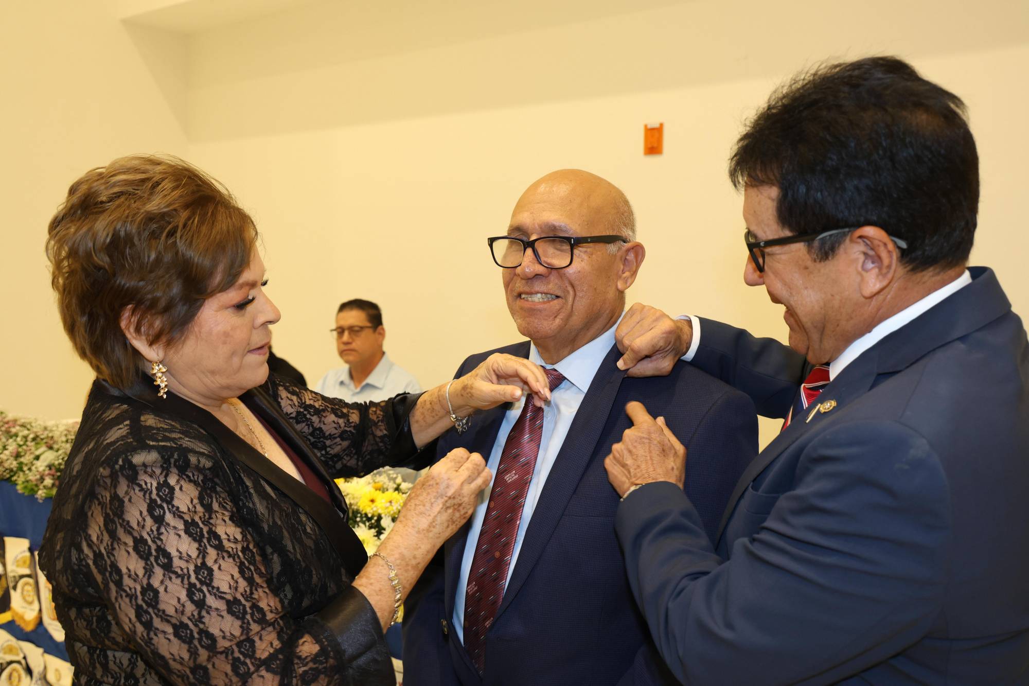 $!María del Carmen Osuna y José de Jesús Sánchez Reynoso colocan el pin de presidente a José Hugo López Machado.