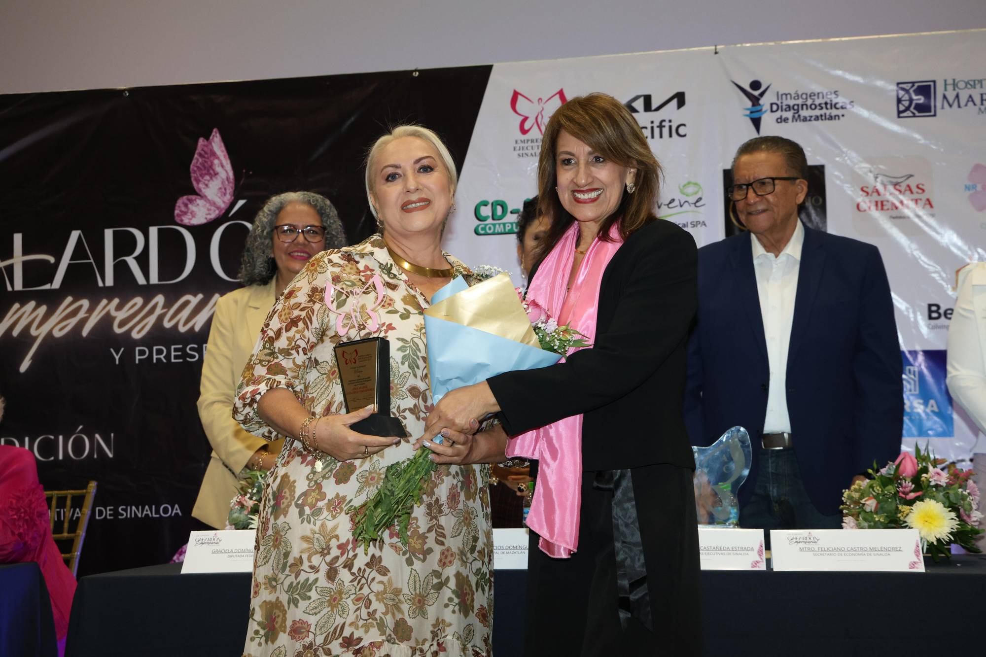 $!Lilia Guillermina Núñez recibió la presea de su mamá Ana Isabel Sánchez Gutiérrez, quien no pudo asistir al evento. Aquí junto a la social Elva Alicia Rose.