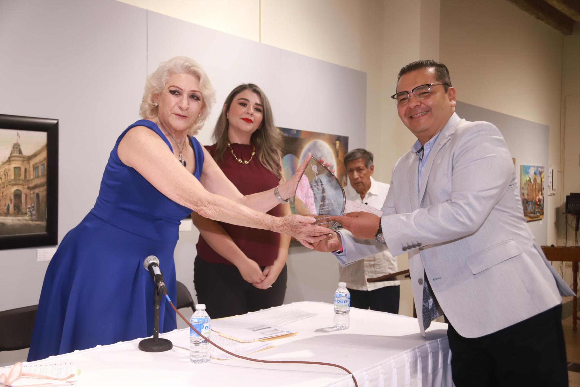 $!Olga María Enciso hace entrega del galardón al escritor Luis Antonio Rincón García.