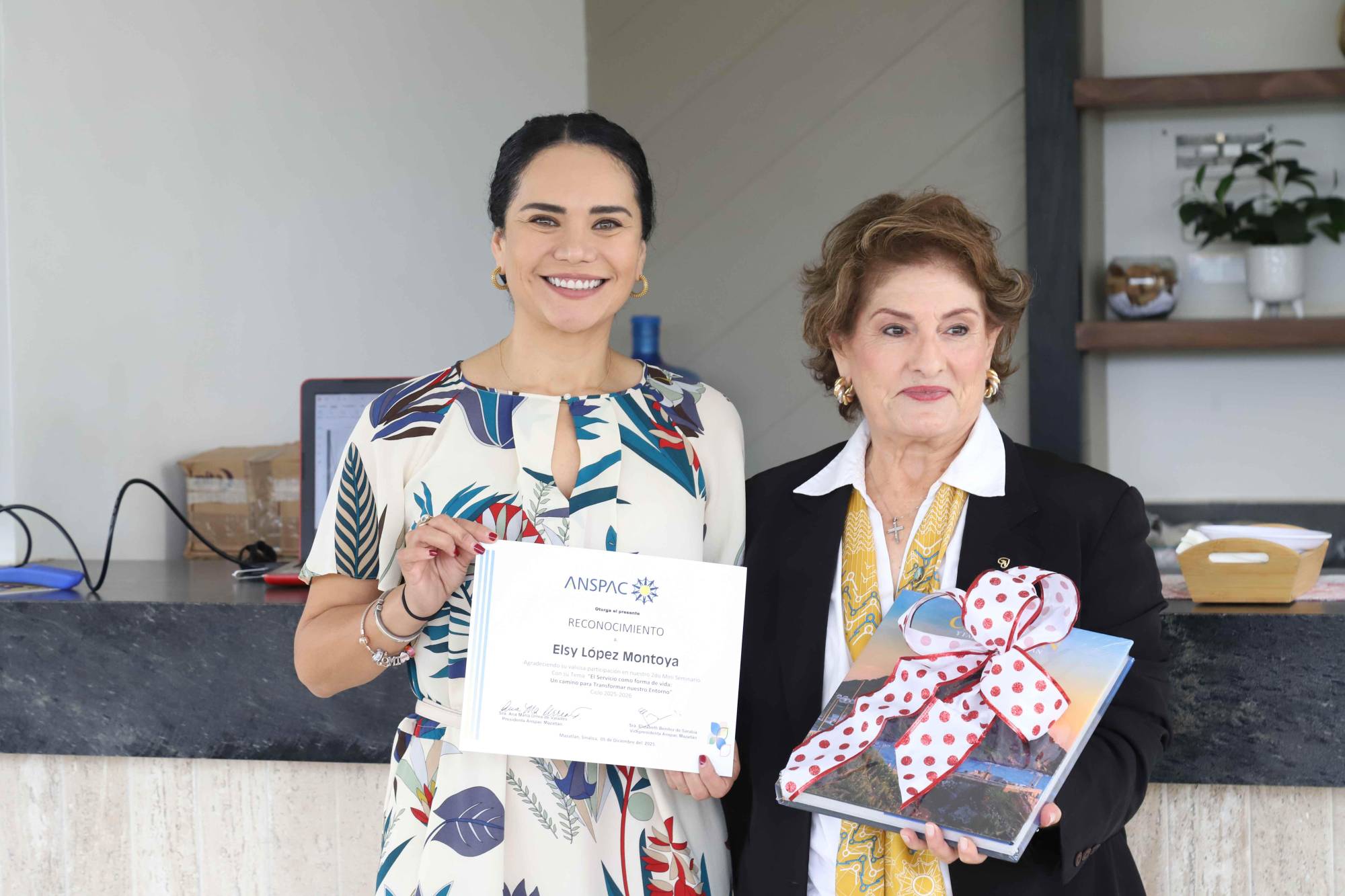 $!Elsy López Montoya recibe un reconocimiento y obsequio de manos de Coco Urrea de Valadés, presidenta de Anspac Mazatlán.