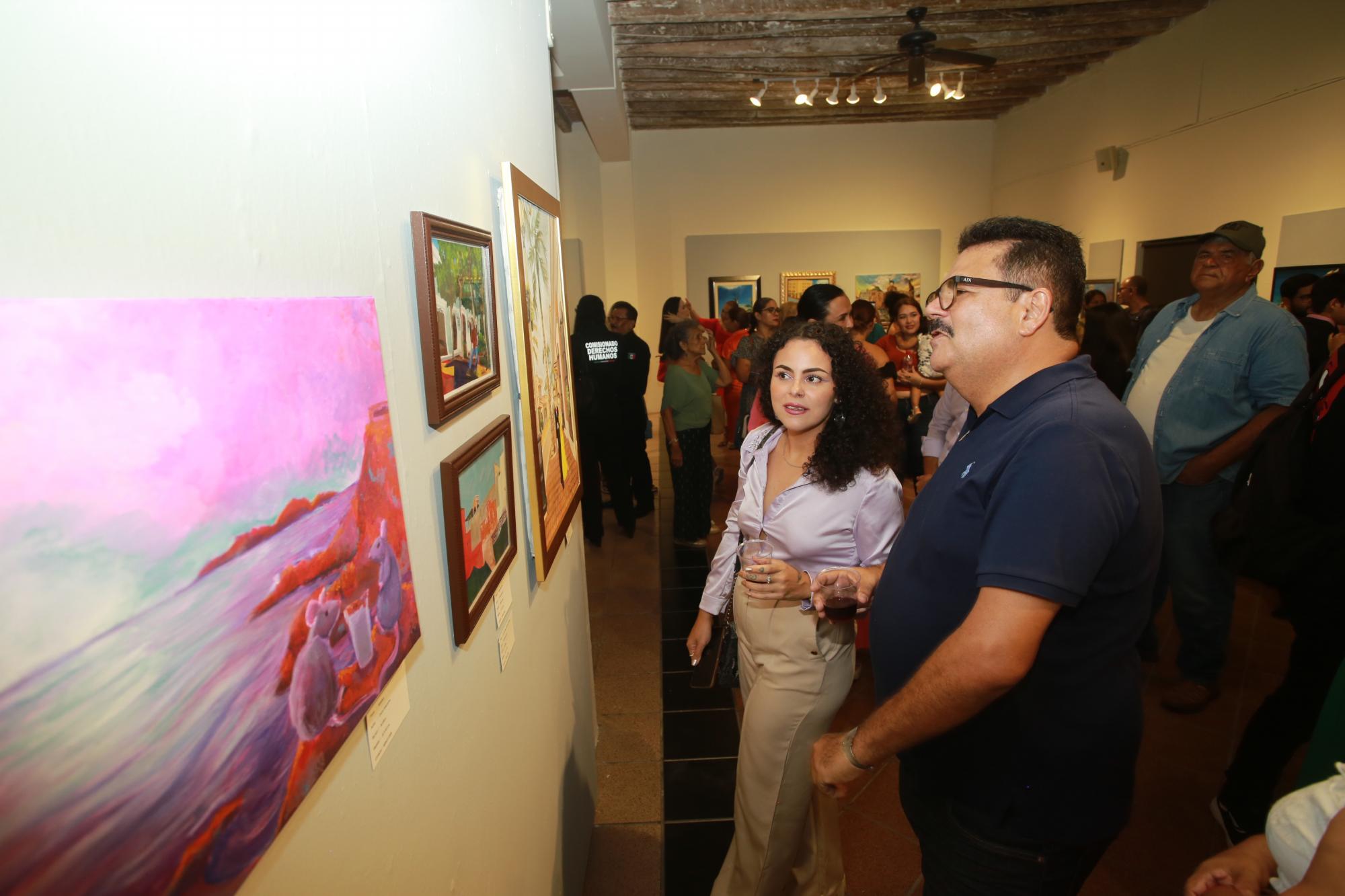 $!Edith Guevara y Juan José Rodríguez admiran algunas de las obras.