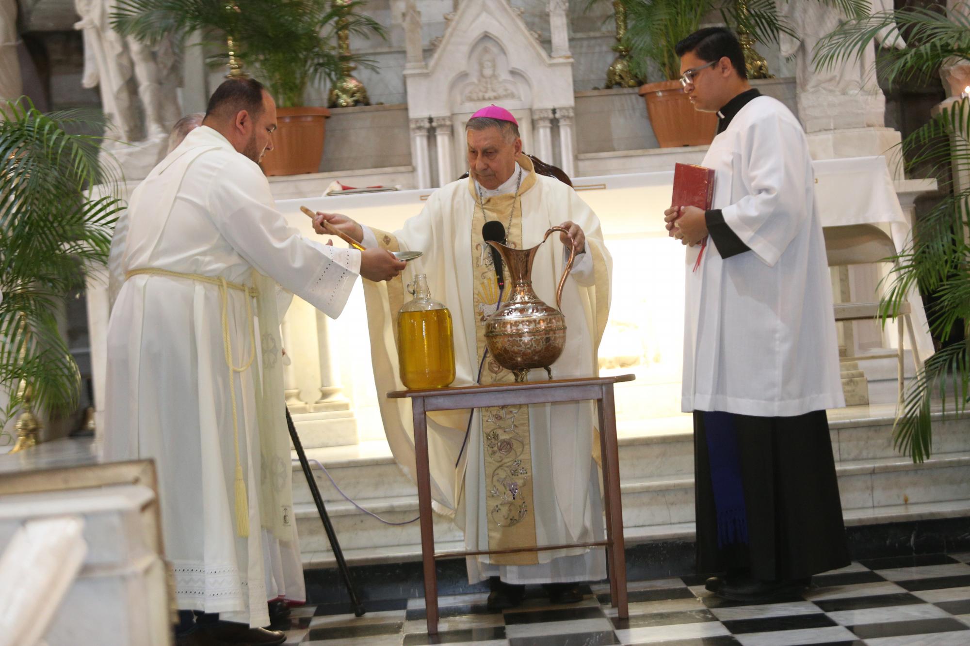 $!El Padre Adán Pasos y el seminarista Ricardo Palomera ayudan al Obispo durante la bendición de los Santos Óleos.