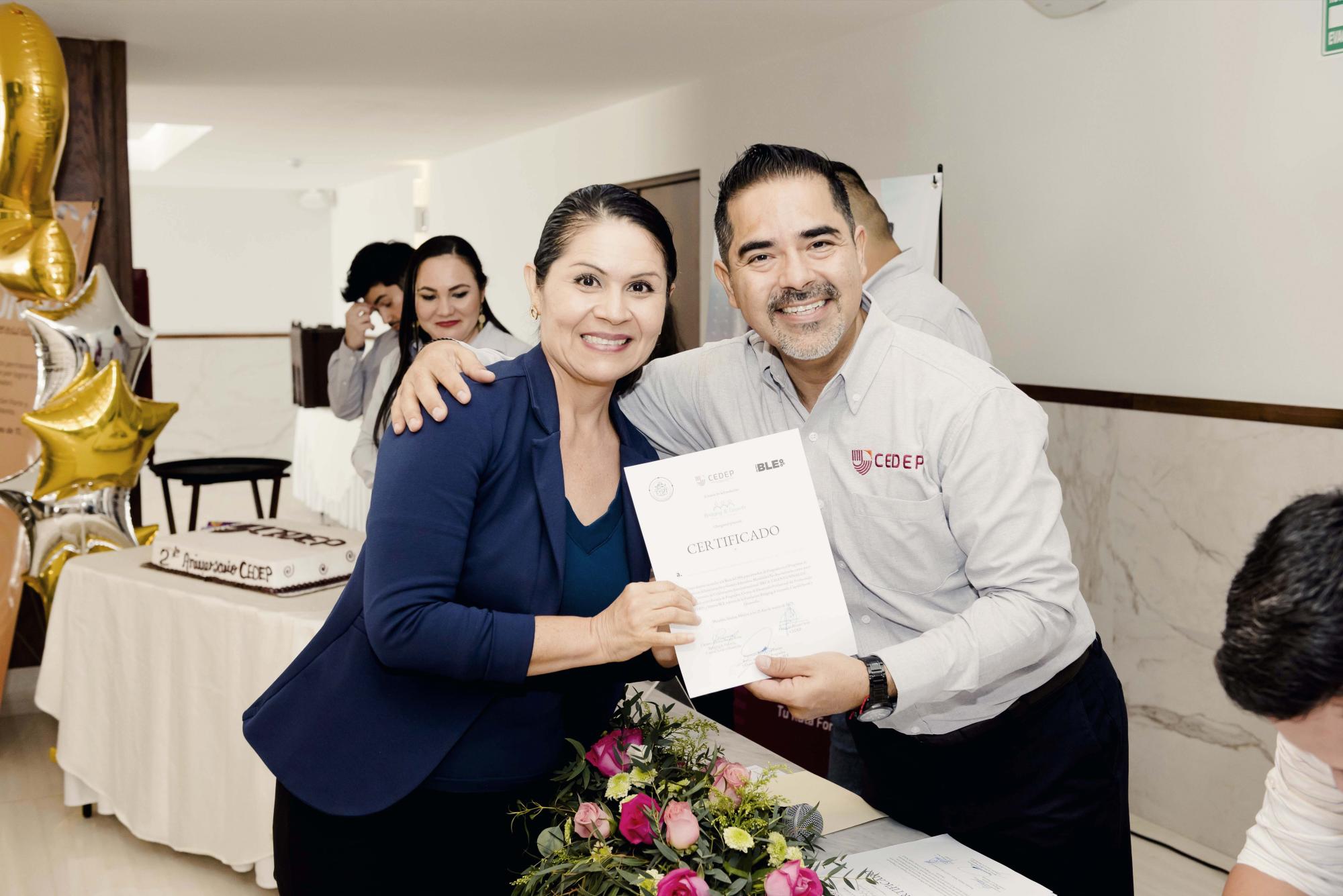 $!La maestra María Magdalena Camacho con su certificado de beca.