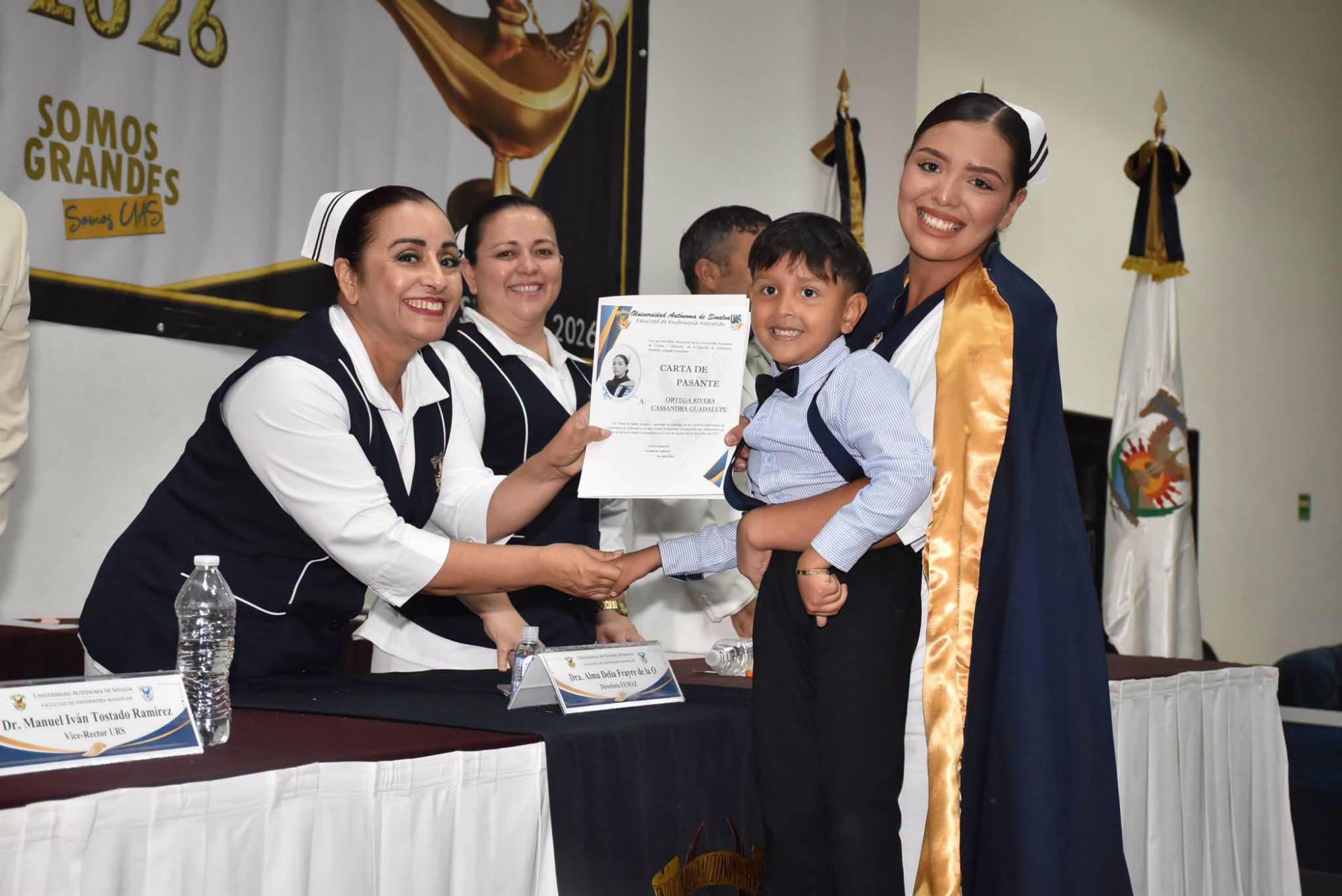 $!Cassandra Ortega recibe su carta de pasante, acompañada por su pequeño, durante la ceremonia de graduación.