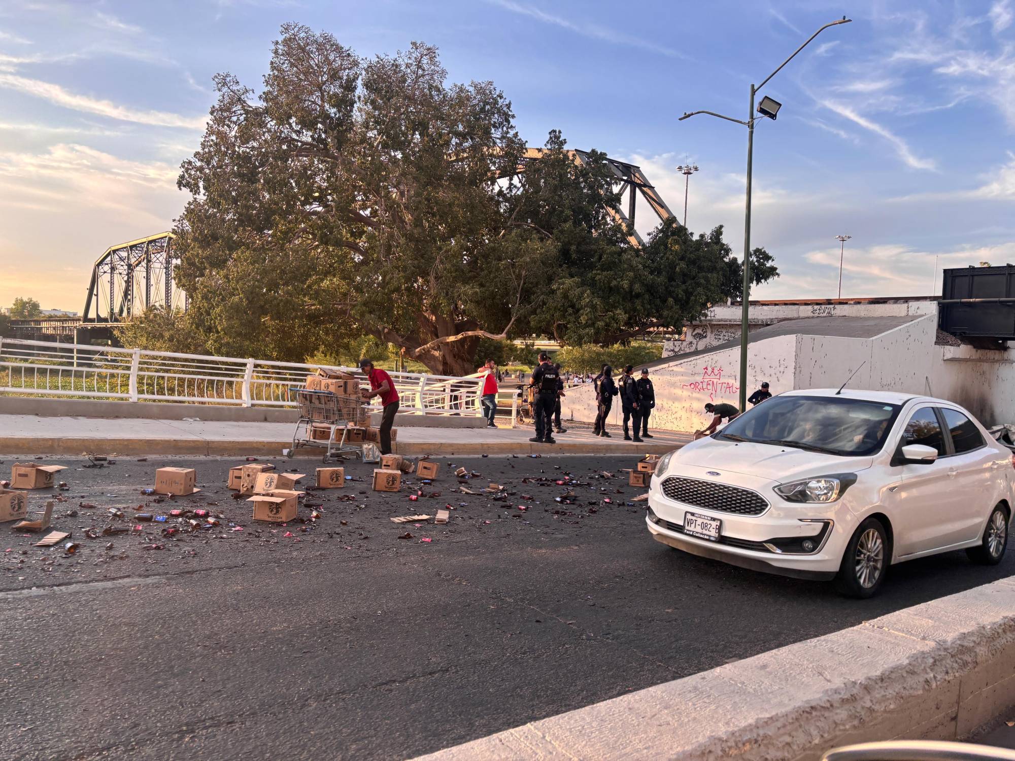 $!Camionero pierde el control y deja varias cajas de cervezas regadas debajo del Puente Negro de Culiacán