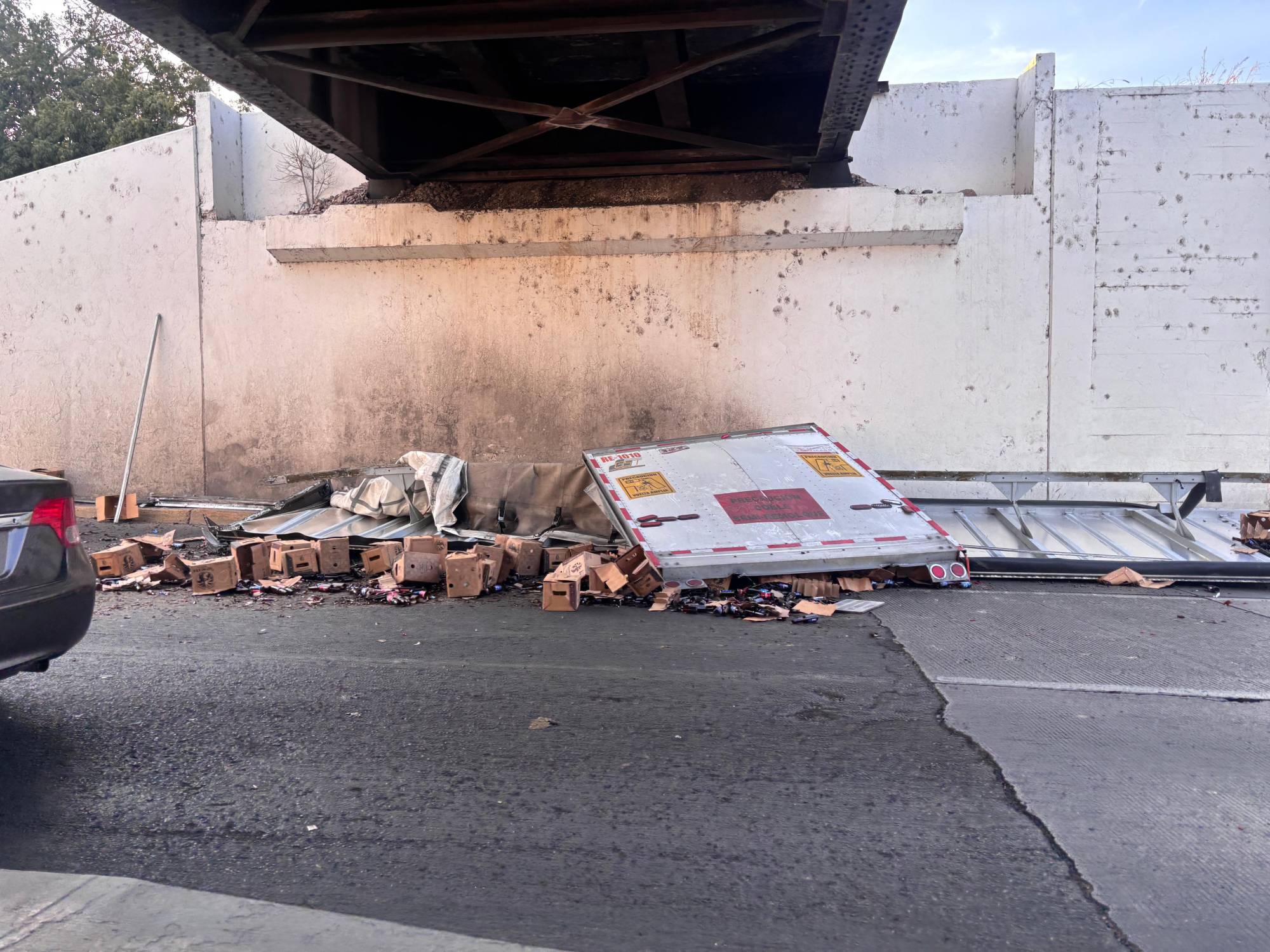 $!Camionero pierde el control y deja varias cajas de cervezas regadas debajo del Puente Negro de Culiacán