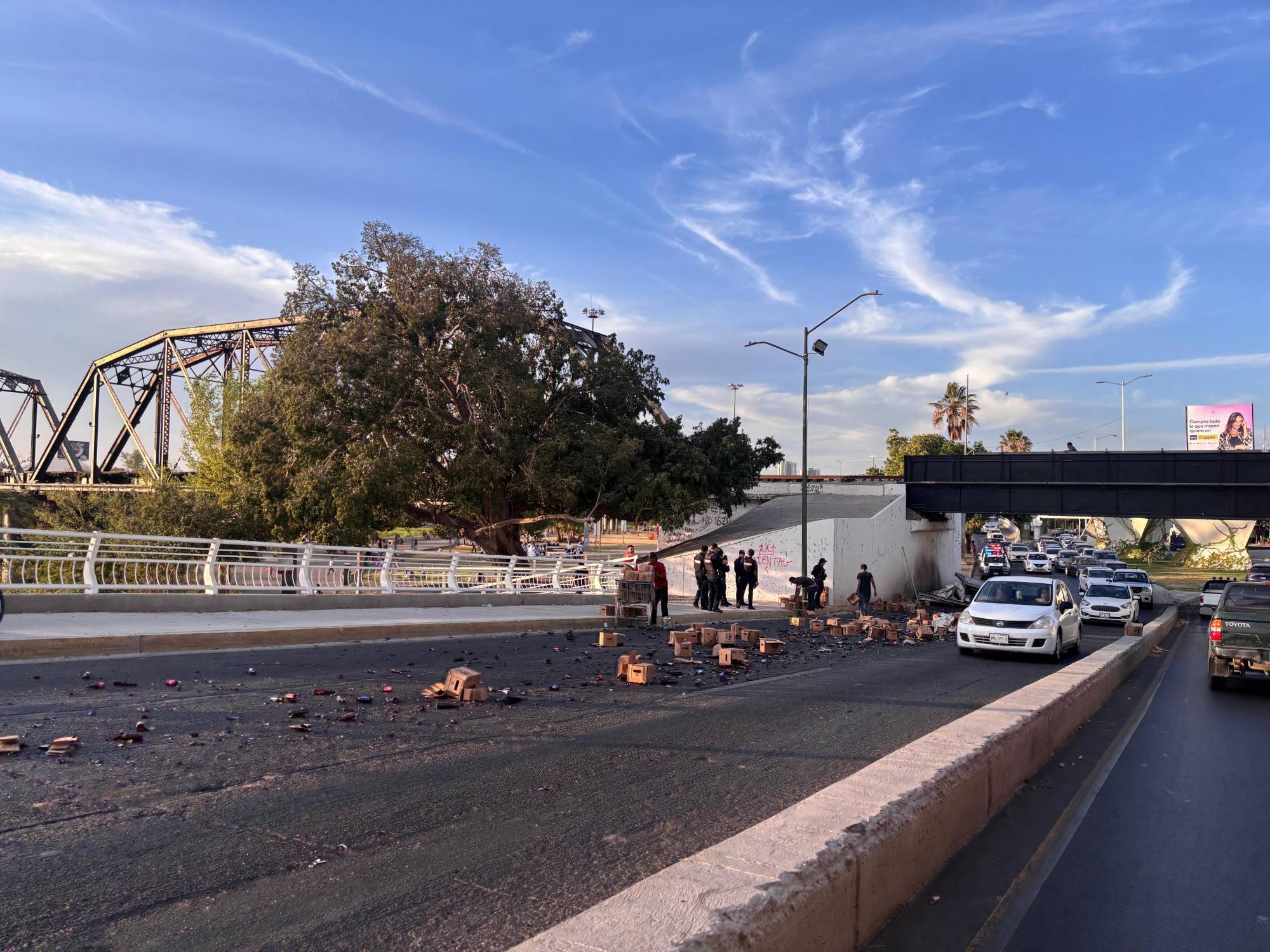 $!Camionero pierde el control y deja varias cajas de cervezas regadas debajo del Puente Negro de Culiacán