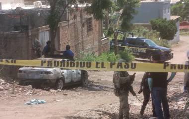 Autoridades de seguridad resguardaron la zona donde un vehículo fue incendiado intencionalmente en Culiacán.