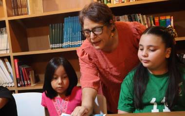 Inna Teresa Álvarez atendiendo a los integrantes de Estrellitas Lectoras.