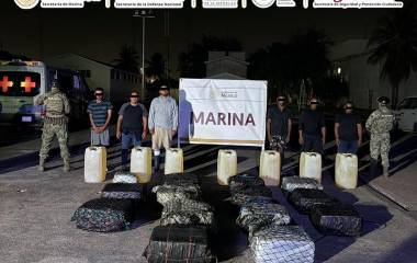 Elementos de la Armada de México custodian los bultos de droga asegurados en el puerto michoacano.