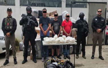 Elementos federales resguardan a los detenidos junto con la dorga asegurada.