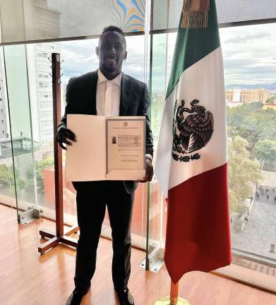 Julián Quiñones muestra su carta de naturalización.