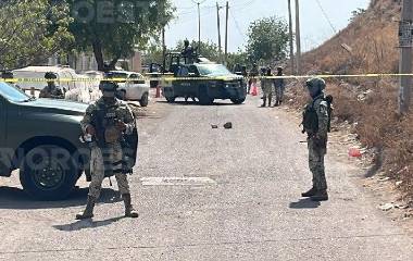 Militares resguarda el perímetro donde fue asesinado un hombre dentro de un taller mecánico.
