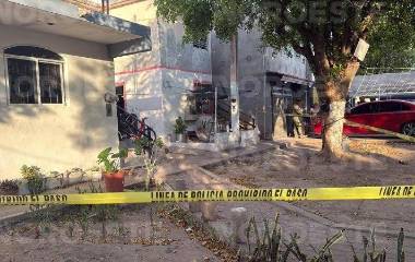 Peritos de la Fiscalía estatal realizan las diligencias en el domicilio donde ocurrió la agresión armada.
