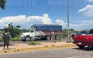 Elementos del Ejército resguardan el tráiler asegurado en La Presita, al norte de Culiacán.