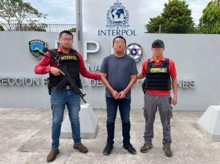 El mexicano detenido permanece resguardado por un agente de seguridad tras su captura en San Pedro Sula.