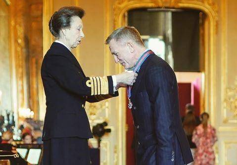 La Princesa Ana de Inglaterra entrega la condecoración a Daniel Craig.