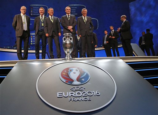 Directivos de la UEFA presentan el sorteo de grupos en presencia del trofeo de campeón.