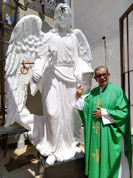 $!José de Jesús Aguilar Enríquez, párroco del Santuario Santa María de América, con la figura gigante de San Gabriel Arcángel.