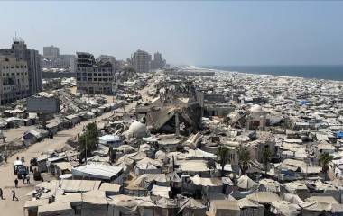 Un enorme asentamiento de tiendas de campaña con residentes desplazados se extiende a lo largo de la costa dañada de Gaza.