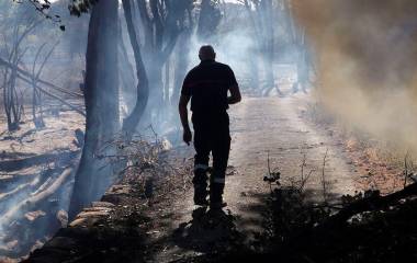 Un bombero inspecciona los restos humeantes de un incendio forestal en el sur de Francia.