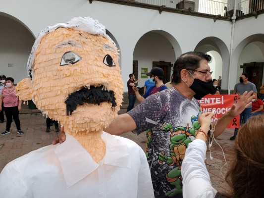 Marco Flores, quien dijo es comerciante, acudió al Palacio Municipal con una piñata con la imagen del Alcalde Jesús Estrada Ferreiro.