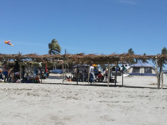 Decenas de familias acampan en la playa de El Caimanero, en Rosario