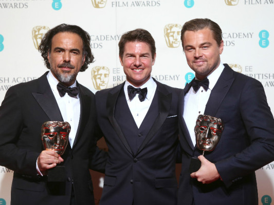 Alejandro González Iñárritu y Leonardo DiCaprio posan con el premio junto al actor estadounidense Tom Cruise, presentador de los Premios BAFTA.