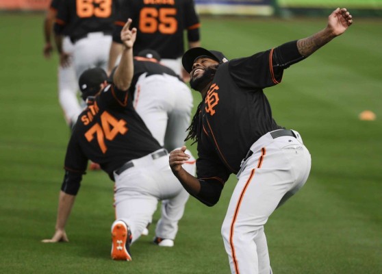 Johnny Cueto calienta en el entrenamiento de Gigantes de San Francisco.