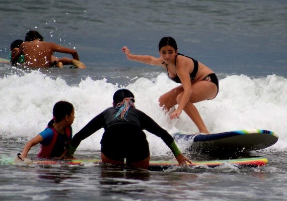 Los jóvenes surfistas muestran sus habilidades en la tabla.