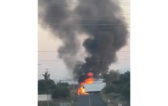 Uno de los tramos carreteros bloqueados con vehículos incendiados.