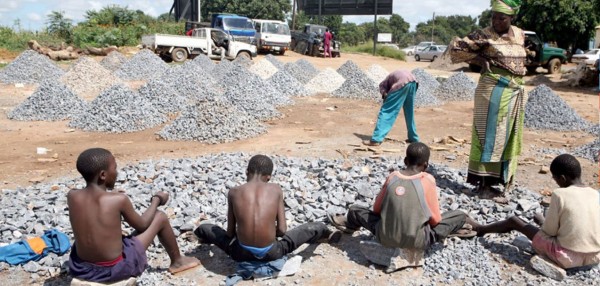 Una mujer observa a los niños que trabajan en una cantera de piedra, Zambia. Foto: Tomada de news.un.org
