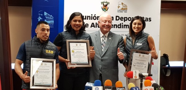 Jonathan Muñoz, Briseida Acosta e Itzel Manjarrez reciben los reconocimientos de manos del Rector Juan Eulogio Guerra Liera.