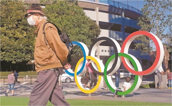 Un individuo observa el calendario con la cuenta regresiva para el inicio de los Juegos Olímpicos de Tokio 2020, el lunes 4 de enero de 2021, en Tokio.