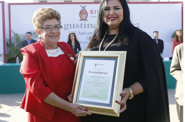 Clementina Burgos Heras recibe la distinción de Rosa Elena Millán.