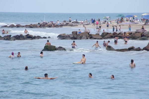 Mitigan centenas de personas el calor en las playas de Mazatlán