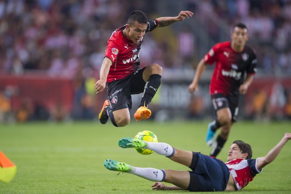 Carlos Fierro se barre sobre el atlista Cristian González.