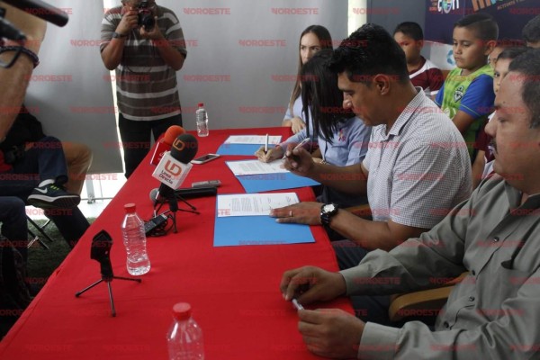 Momentos en que Adán Amezcua y Cindy Mejía firman el convenio de colaboración.