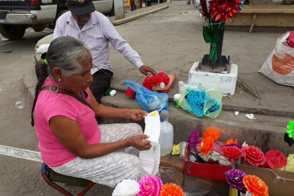 El matrimonio se dedica a elaborar coronas de papel para el día de la Virgen.