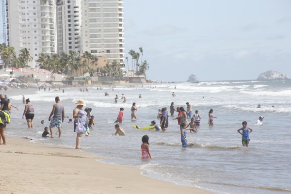 Mitigan centenares de personas el calor en playas de Mazatlán