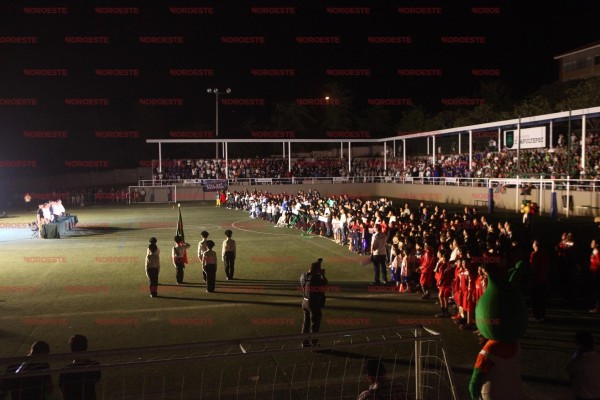 Los asistentes rinden honores a la bandera nacional.