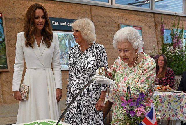 La Reina Isabel II corta pastel con espada.