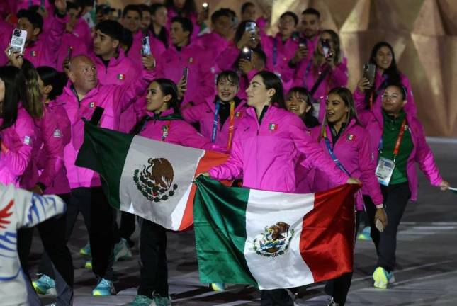 La ciclista sinaloense Luz Daniela Gaxiola lleva una bandera de México en la ceremonia inaugural.
