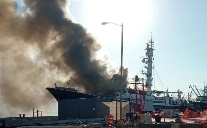 Una densa nube negra se eleva del Atunero BM El Dorado tras el incendio que sufrió este sábado.